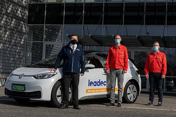 Vertreter von Leadec und Audi Hungaria bei der Übergabe eines E-Autos.
