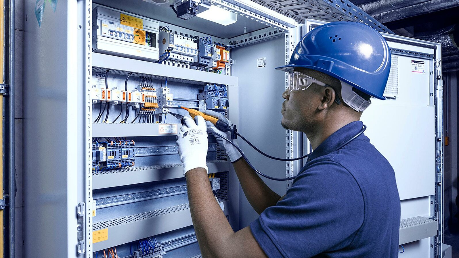 Leadec-Mitarbeiter bei der Reparatur eines Schaltschranks.