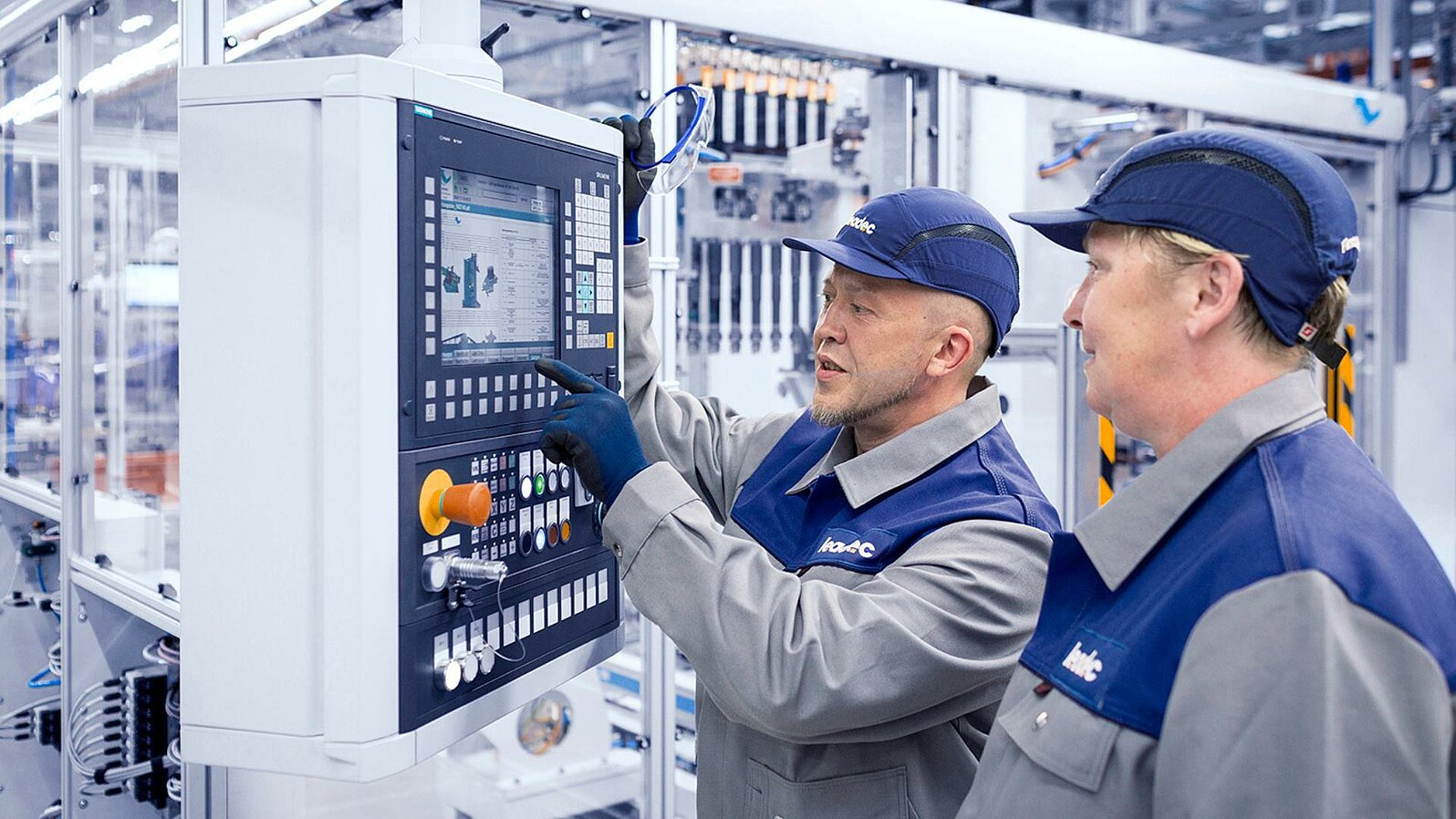 Zwei Leadec-Mitarbeiter überprüfen das Display einer Automatikstation.