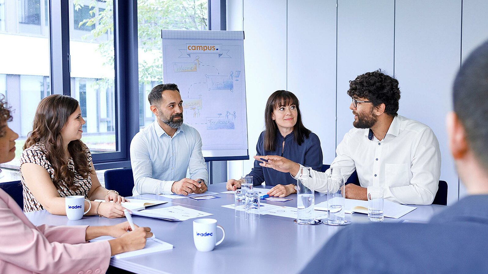 Eine Gruppe von Leadec-Mitarbeitenden bei einem Meeting in einem Konferenzraum. 