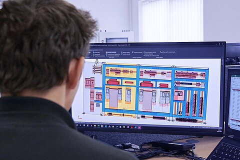 Ein Mitarbeiter bei der Planung von Automatisierungslösungen am PC.