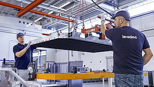Zwei Leadec-Mitarbeiter beim Handling eines Batteriegehäuses.