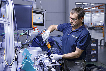 Leadec Mitarbeiter bei der Vormontage von Zusammenbauteilen für Elektrofahrzeuge.