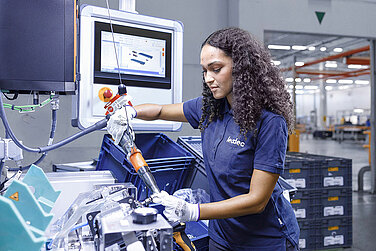 Leadec Mitarbeiterin bei der Vormontage von Zusammenbauteilen für Elektrofahrzeuge.