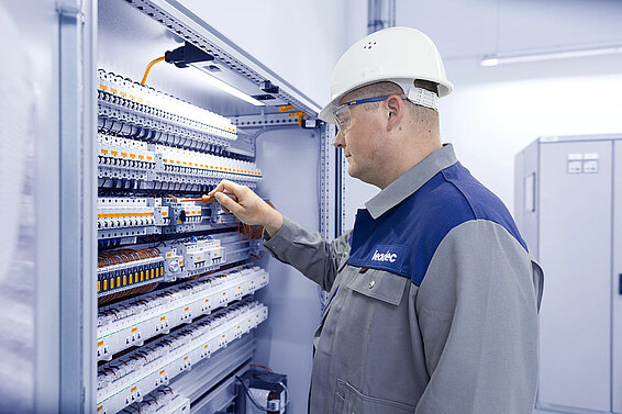 Ein Leadec-Mitarbeiter bei der Arbeit an einem Schaltschrank.