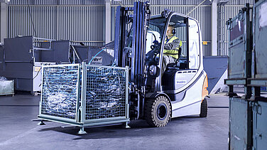 Ein Leadec-Mitarbeiter transportiert mit einem Gabelstapler eine Palette mit Abfall durch die Fabrik.
