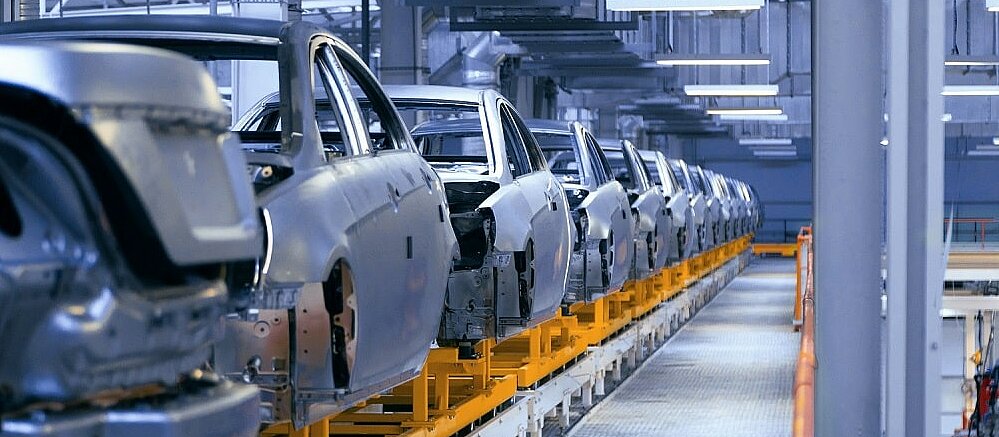 Autokarossen auf einem Förderband in einer Fabrik. 