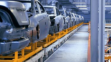 Autokarossen auf einem Förderband in einer Fabrik. 