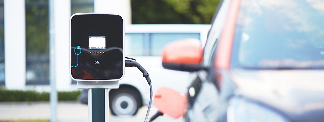 Ein Elektrofahrzeug an einer Ladestation mit einem Plugin.