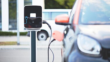 Ein Elektrofahrzeug an einer Ladestation mit einem Plugin.