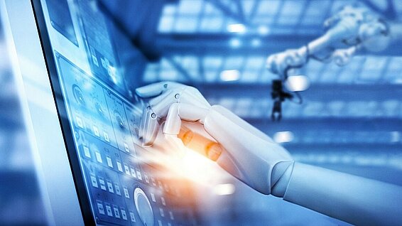 Roboterhand die mit dem Finger auf ein Display drückt.