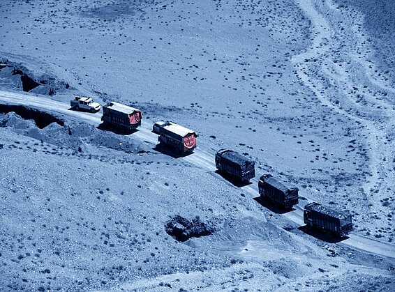 Konvoi von Lastwagen, die in der Wüste fahren. 