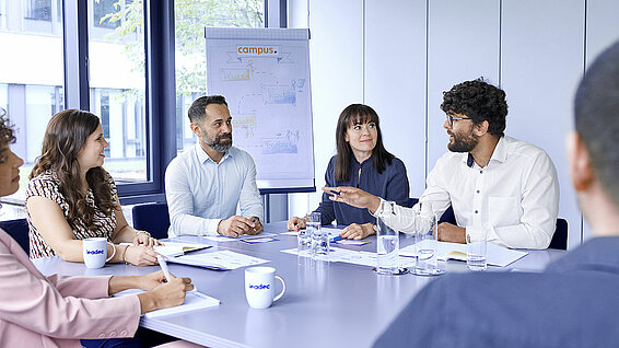 Eine Gruppe von Leadec-Mitarbeitenden bei einem Meeting in einem Konferenzraum. 