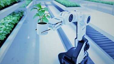 Ein Roboterarm an einem Fließband hält eine grüne Pflanze.