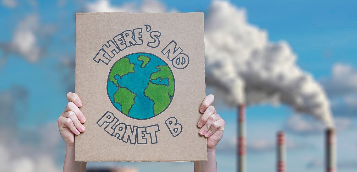 Zwei Hände halten ein Schild hoch mit der Aufschrift "There is no planet B"